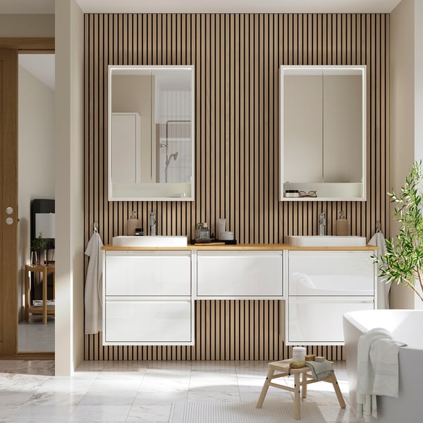Moderne badeværelse med ÄNGSJÖN hvidt skab, to håndvaske og lodrette striber; Slankt design.