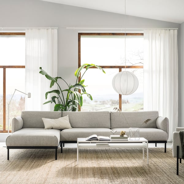 Moderne stue med grå ÄPPLARYD sofa, hvidt sofabord, stor plante og hængende lampe.