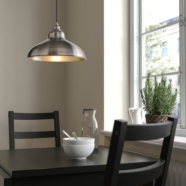 ANKARSPEL lampe over spisebord med mørkt træ, stole og indretning.