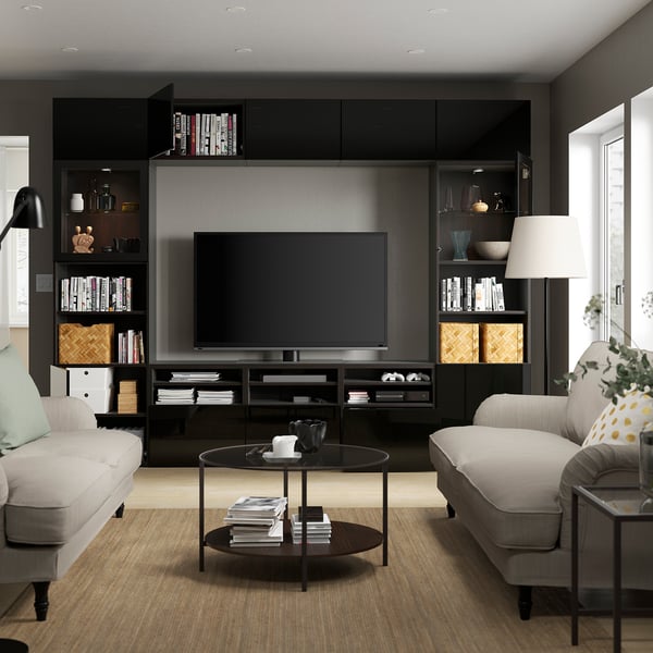 Moderne stue med BESTÅ tv-enhed, sofaer, sofabord med bøger.