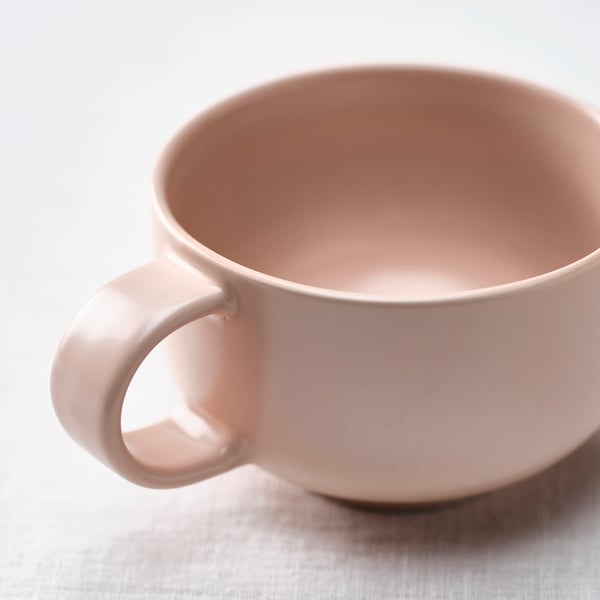 Stort lyserødt krus lavet af glat stentøj med et behageligt håndtag, perfekt til kaffe eller te.