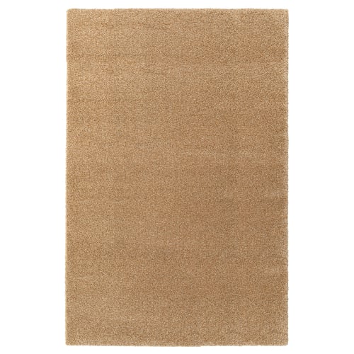 Et almindeligt beige rektangulært tæppe, lavet af polypropylen og syntetisk gummi, med et enkelt design.