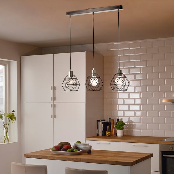 Moderne køkken med hvide BRUNSTA pendler over træøen, der holder frugtskål. Let, geometrisk design komplementerer ren, minimalistisk indretning.