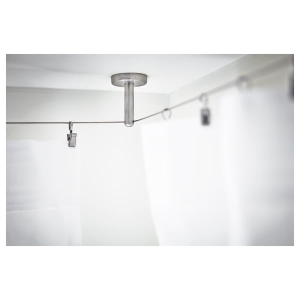Et gardintrådsbeslagssystem. Den fremhæver en metalstang og vægmonterede clips, hvilket sikrer stabilitet og justerbarhed.