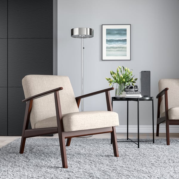 Retro stole, beige, på gråt tæppe ved sort bord med blomster og tablet. Moderne lampe, kunst med havtema i minimalistiske omgivelser.
