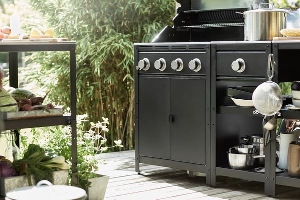 Udekøkken med GRILLSKÄR grill, redskaber, råvarer og grønt.