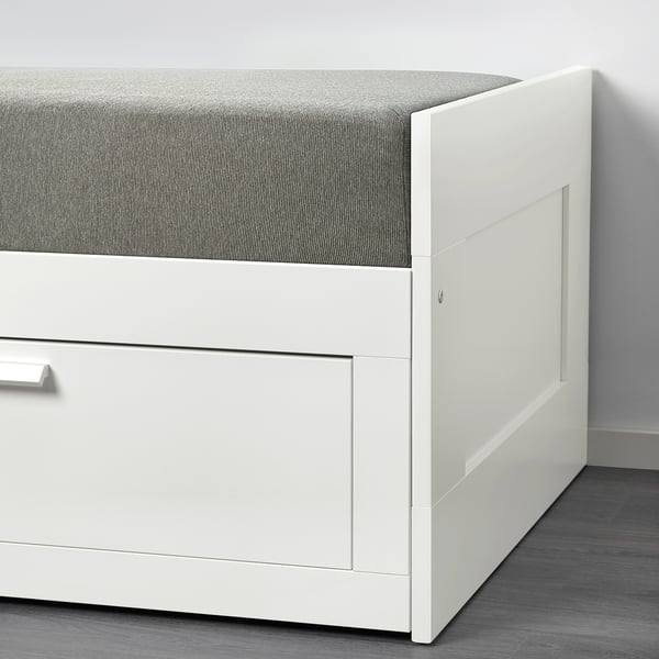 Hvid daybed med grå polstret top, med et stræklagen design for nem vask.