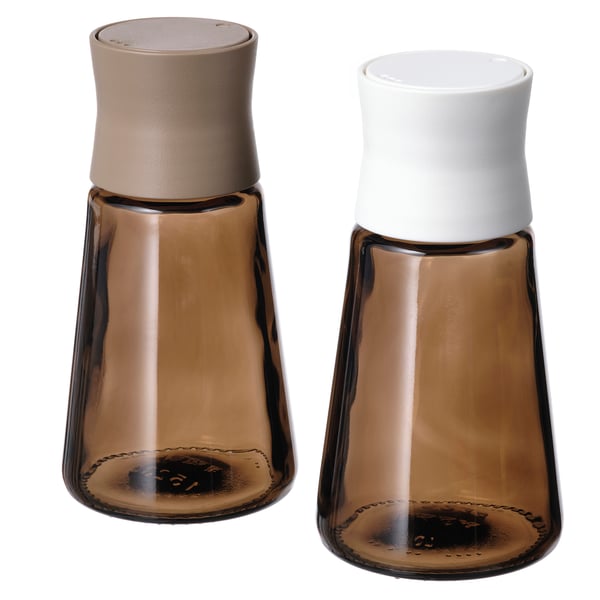 Et par brune krydderiglas i glas med hvide og beige låg, tilspidset form, trendy design.