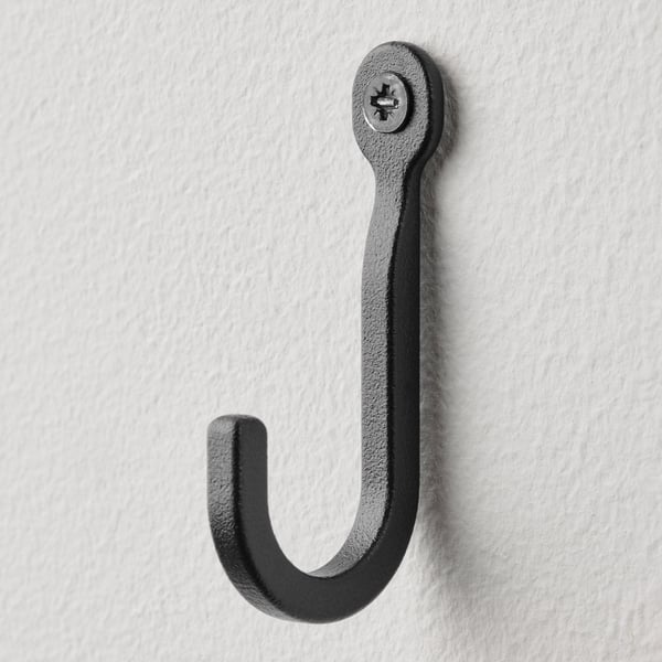 Enkelt sort metalkrog på hvid væg, robust og minimalistisk design.