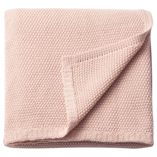 Lyserødt, blødt, foldet tæppe. Fremstillet af genanvendt polyester. Strikket tekstur, rektangulær.