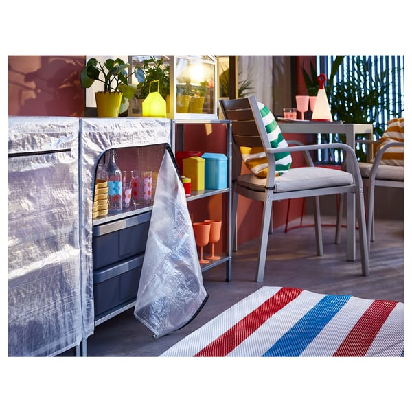 Moderne terrasse med HYLLIS reoler og overtræk, farverige stole, planter og stribet tæppe.