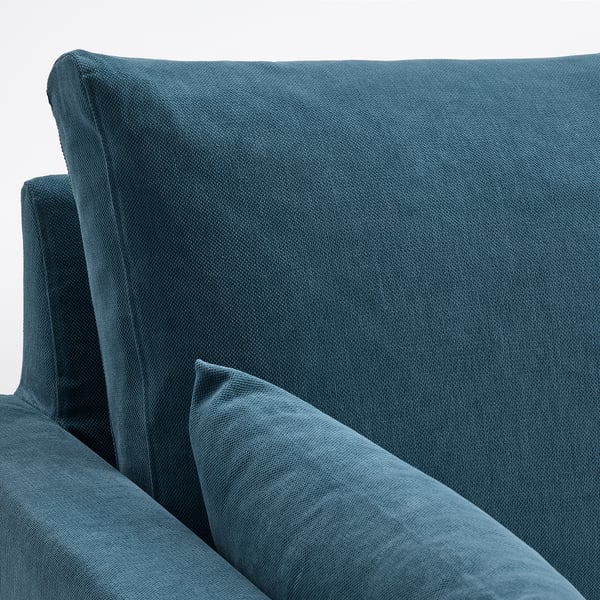 En blød blå sofa, elastiske skumpuder og et hyggeligt, indbydende design, der er fremstillet af materialer af høj kvalitet for komfort og holdbarhed.