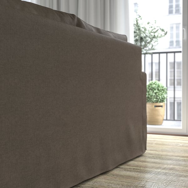 Grå sofa ved vindue, komfort med vendbare hynder.