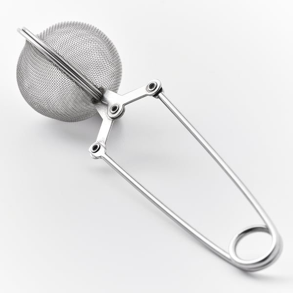 Metal te infusionsenhed med sfærisk netfilter og langt håndtag, designet til brugervenlighed.