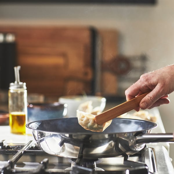Håndvend dumpling i non-stick pande på gaskomfur.
