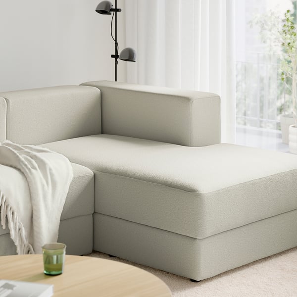 En moderne modulsofa med chaiselong, lampe og tæppe.