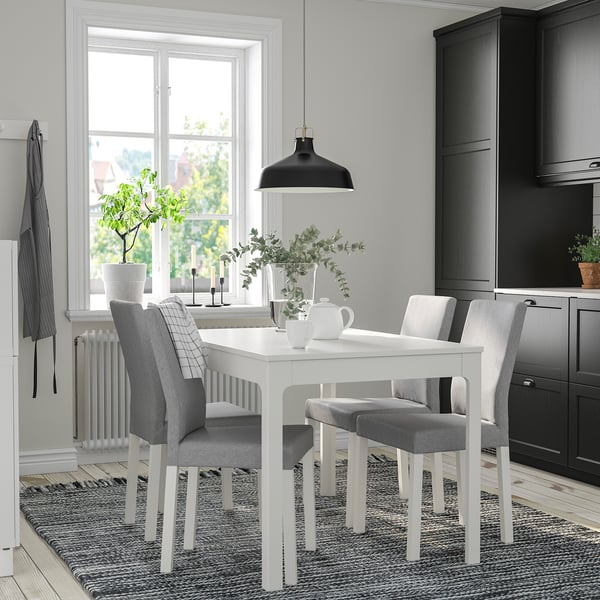 Moderne køkken med spisebord, pendel, plante og vindue.