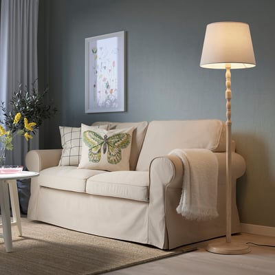 KINNAHULT lampe ved siden af sofa, varmt skær.