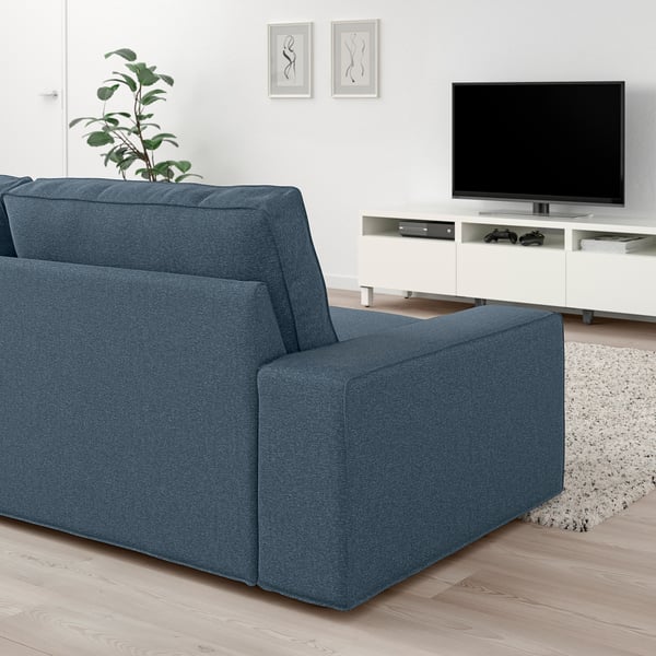 Moderne stue med KIVIK blå sofa, hvidt tv-bord og vægkunst. Sofaen er stor, dyb og indbydende med 10 års garanti.