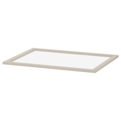 En KOMPLEMENT glashylde i beige. Den har en rektangulær form med en fiberpladeramme og hærdet glascenter, designet til garderobeopbevaring.