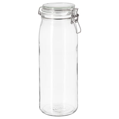En klar glaskrukke ved navn KORKEN med sølvlås og gummipakning, designet til opbevaring af mad eller drikkevarer.