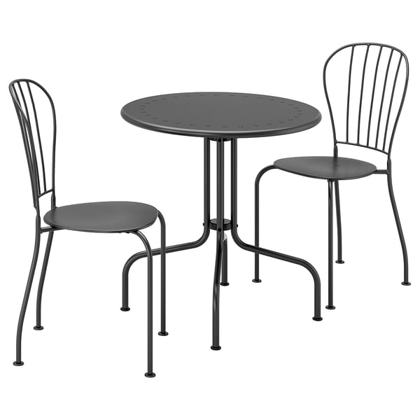 Forestil dig et sort LÄCKÖ udendørsmøbelsæt med et cirkulært bord og to stabelbare stole med perforeret ståldesign.
