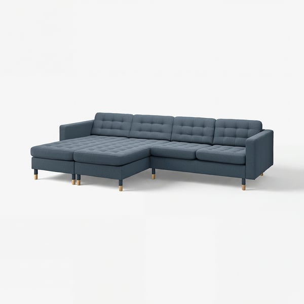 Moderne blå sektionsofa med firkantede puder og træben.