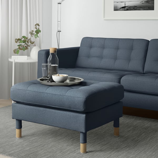 Blå sofa med matchende fodskammel, bruges som ekstra siddeplads eller forlængelse. Inkluderer bakke med glas og skål.