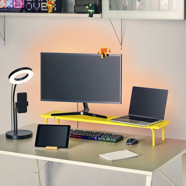 Velorganiseret arbejdsplads med skærmstativ, bærbar computer, tablet, tastatur, mus og lampe, der fremmer ergonomisk spil.