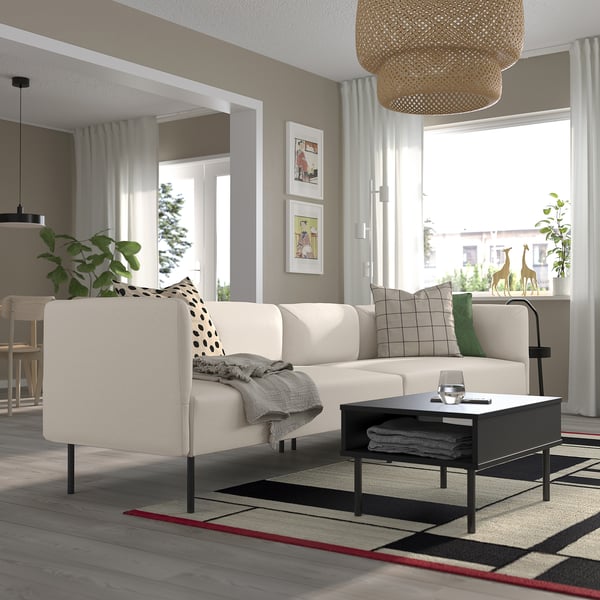 Moderne stue med LILLEHEM sofa, hynder, sofabord, sidebord med plante og stort tæppe.