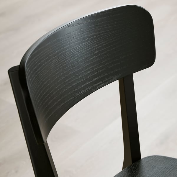 Sort træstoleryglæn, udformet med glat, fineret ask, der viser robust, elegant design i moderne indretning.
