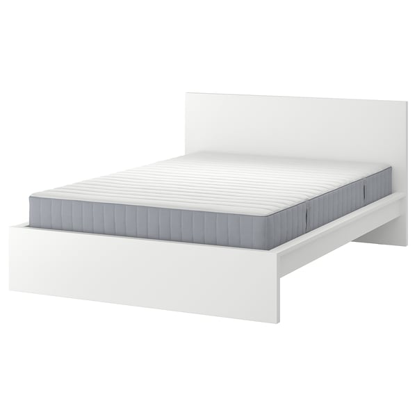 Minimalistisk hvid seng, rent design, rektangulær form, med grå quiltet madras.