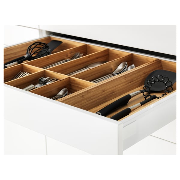 Køkkenskuffearrangør i træ med redskaber og madlavningsredskaber i separate sektioner.
