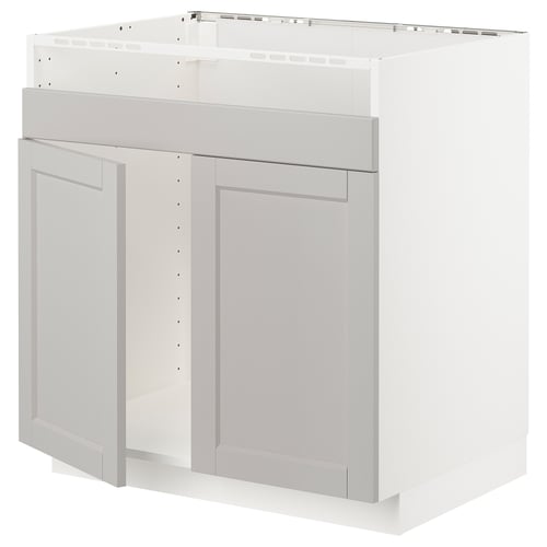 Et hvidt METOD køkkenskab med lysegrå lerhyttan-låger med skrå kanter og et traditionelt design.
