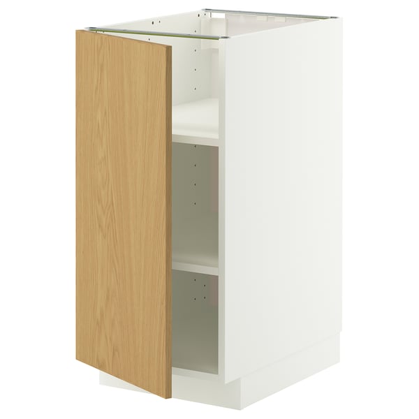 Et hvidt METOD køkkenskab med en lys egetræslåge, med et minimalistisk design og justerbare hylder.