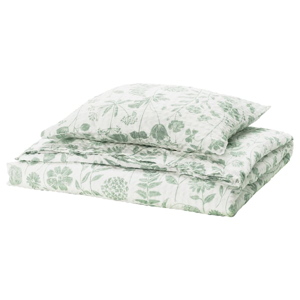 Grønt blomsterdynesæt fra IKEA NÅLBJÖRNBÄR. Hvidt stof med grønne blade, blomster, rektangulær form, seersucker-tekstur.
