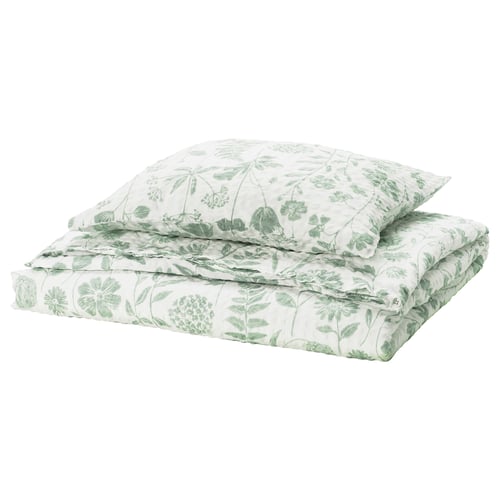 Grønt blomsterdynesæt fra IKEA NÅLBJÖRNBÄR. Hvidt stof med grønne blade, blomster, rektangulær form, seersucker-tekstur.