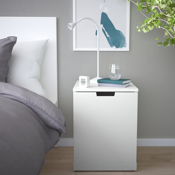 Moderne soveværelse med NORDLI kommode, lampe, bøger og kunst.