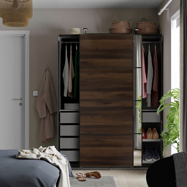 Soveværelse med PAX-garderobe med skydedøre, hængende tøj, hylder og spejl.