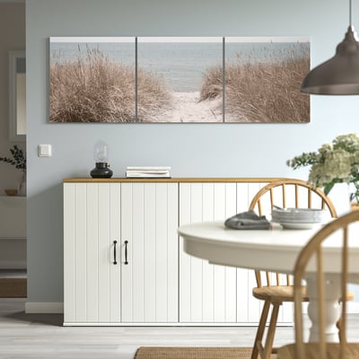 Triptykon strandscenekunst over skænken tilføjer dybde til minimalistisk indretning.