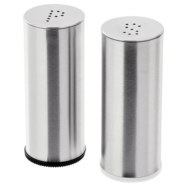 To salt- og peberbøsser i rustfrit stål, cylindriske med en ribbet bund til greb, hver toppet med et dusin små huller til dispensering af krydderier.