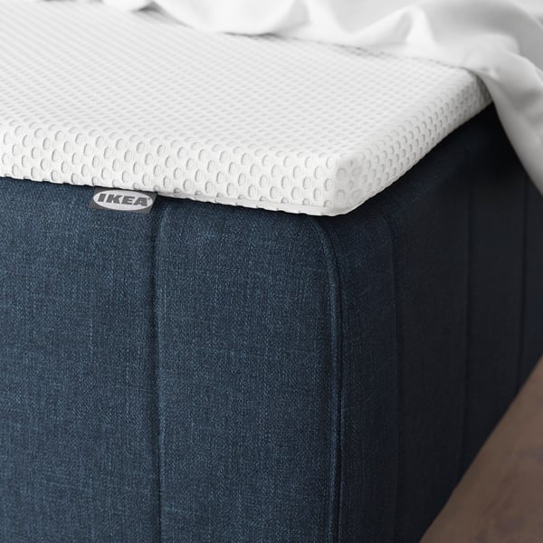 En memory foam madras-topper på sengen, med køling og komfortzoner til rygsøjlens justering.