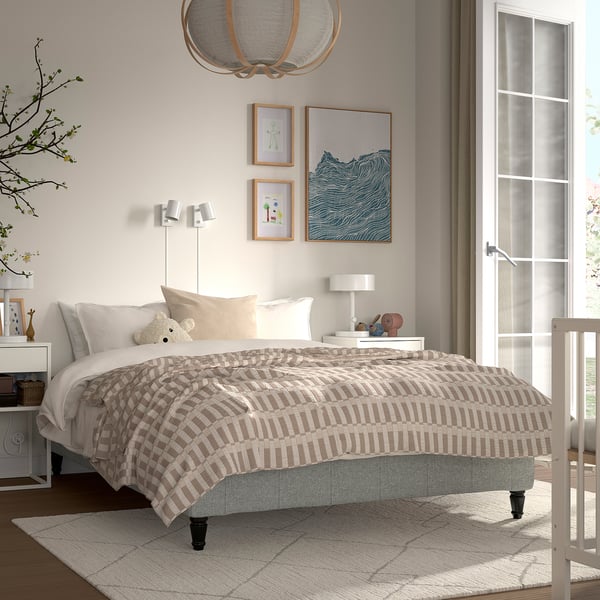 Beige & hvid RENFJÄLLET seng med stribet dyne, blød pendel, minimalistisk indretning.