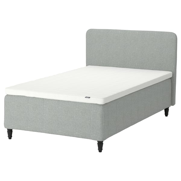 En grå RISHÖJDEN-seng med en hvid madras med 7 komfortzoner til rygstøtte. Den har et enkelt, elegant design med sorte ben.