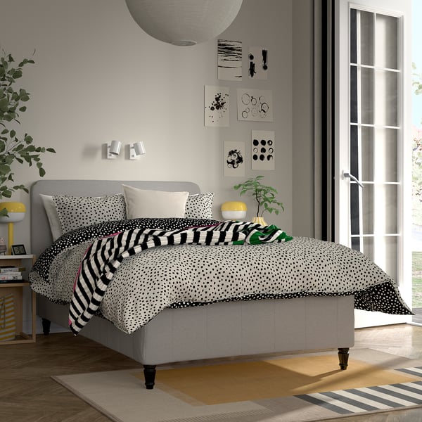 Moderne soveværelse med stor RISHÖJDEN seng, sort-hvidt sengetøj, gråt sengegavl, retro prints, plante og store vinduer.