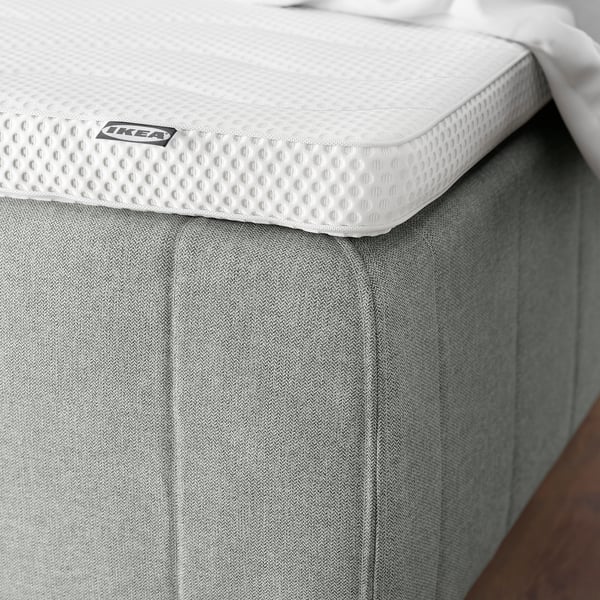 Moderne madras med forstærkede kanter, pocketfjedre, blød pude, grå tekstureret betræk, IKEA-mærke.