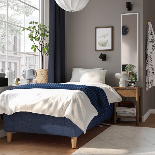 Moderne blåt soveværelse med RISHÖJDEN-seng, spejl, planter.