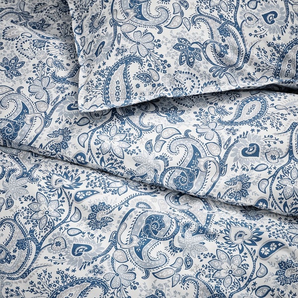 Indviklet blåt paisley-sengetøj på blødt, foldet stof, der viser detaljerede mønstre af høj kvalitet.