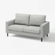 Moderne grå stof-loveseat, slankt design, to puder, sorte ben.