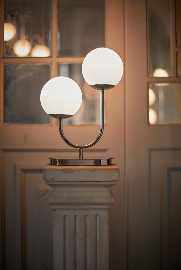 Moderne dobbelt globuslampe på piedestal, slank kromfinish, opalglasskærme.
